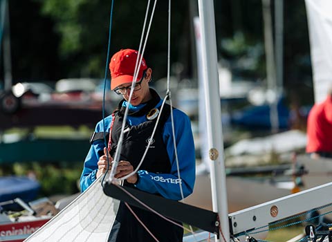 sailor assembling sail on dinghy 