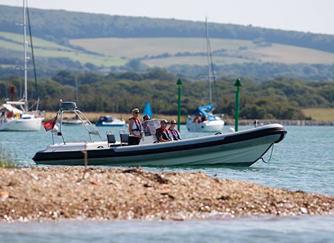 wide shot of group of people in motor boat