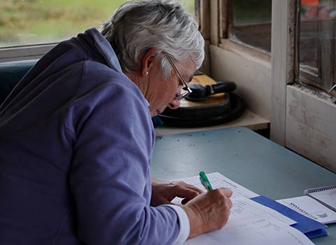 member of club filling in documentation with pen and paper 