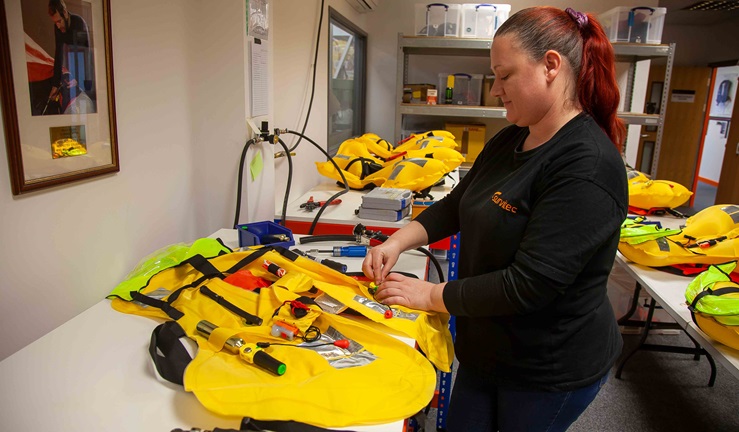 Wide shot of woman servicing and checking a lifejacket
