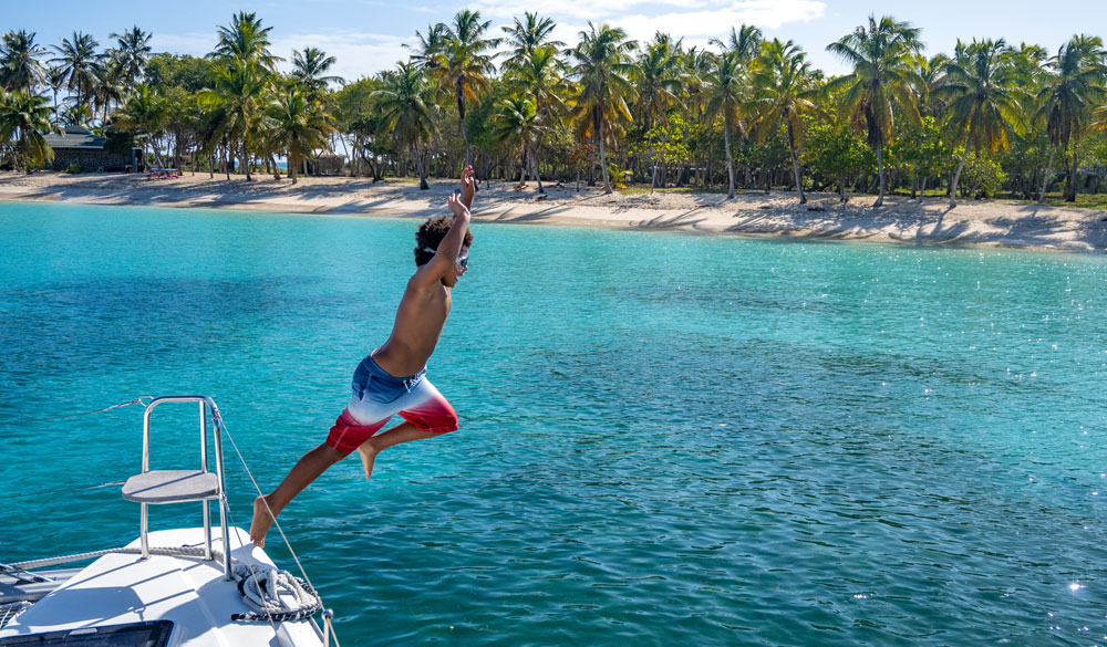 child jumping into blue water
