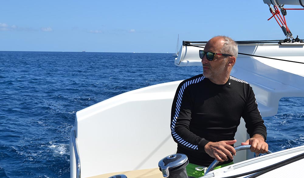Arnaud Coville on a yacht sailing in the sunshine