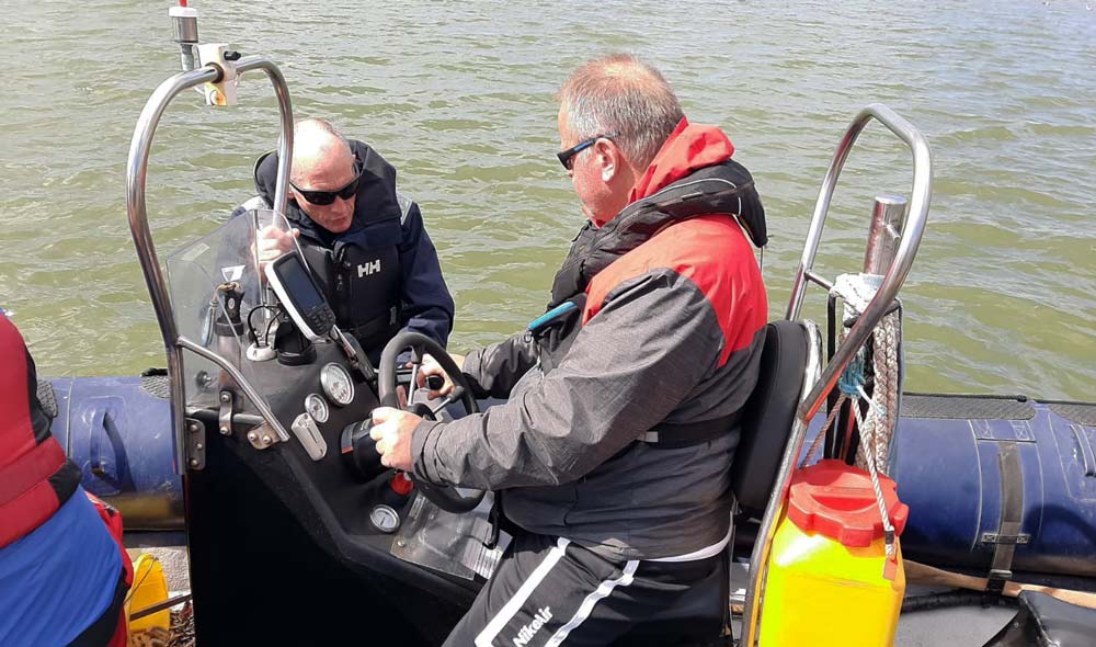 Dave on the helm (in red) with Phil Hastain (in black)