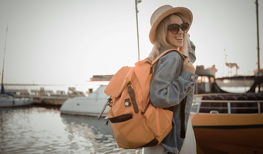 wide shot of woman tourist with large travel bag