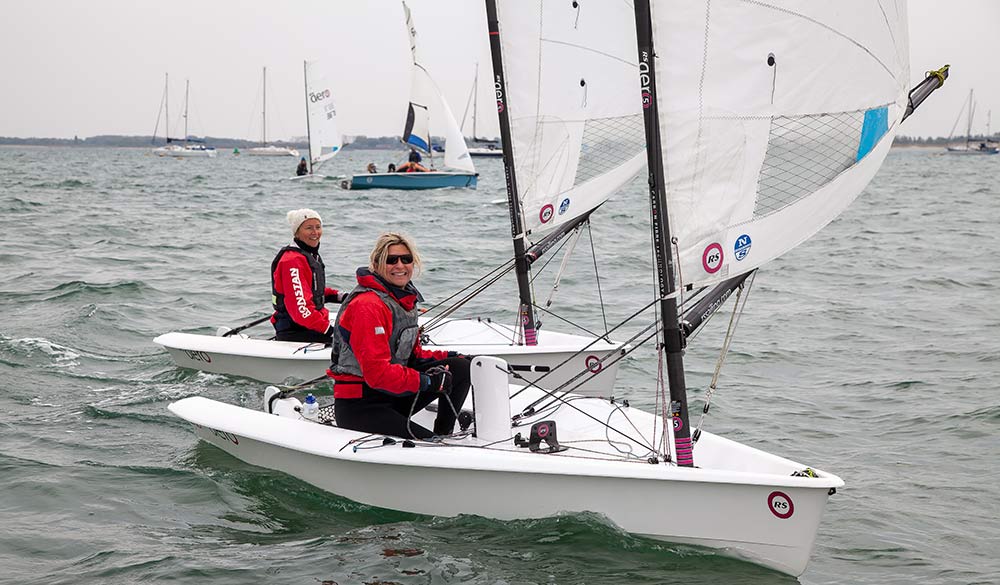 wide shot of women sailing with other boats