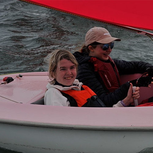 Vanessa sailing with her dog on a dinghy on the river