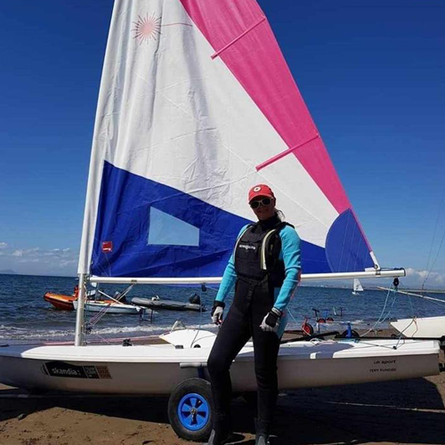 Laura Cowan standing in front of her dinghy