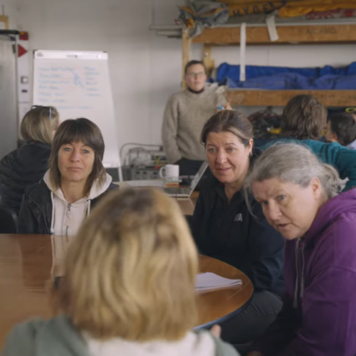 Multiple women having a discussion around a table