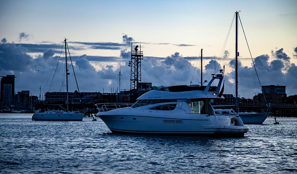 Boat sailing at dusk with its navigation lights on 