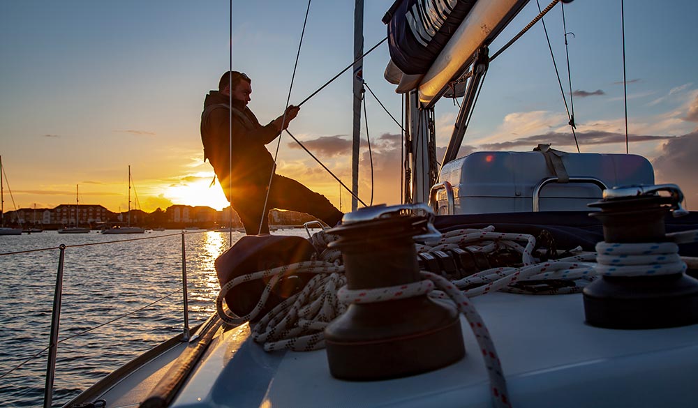 Man sailing from dawn to dusk