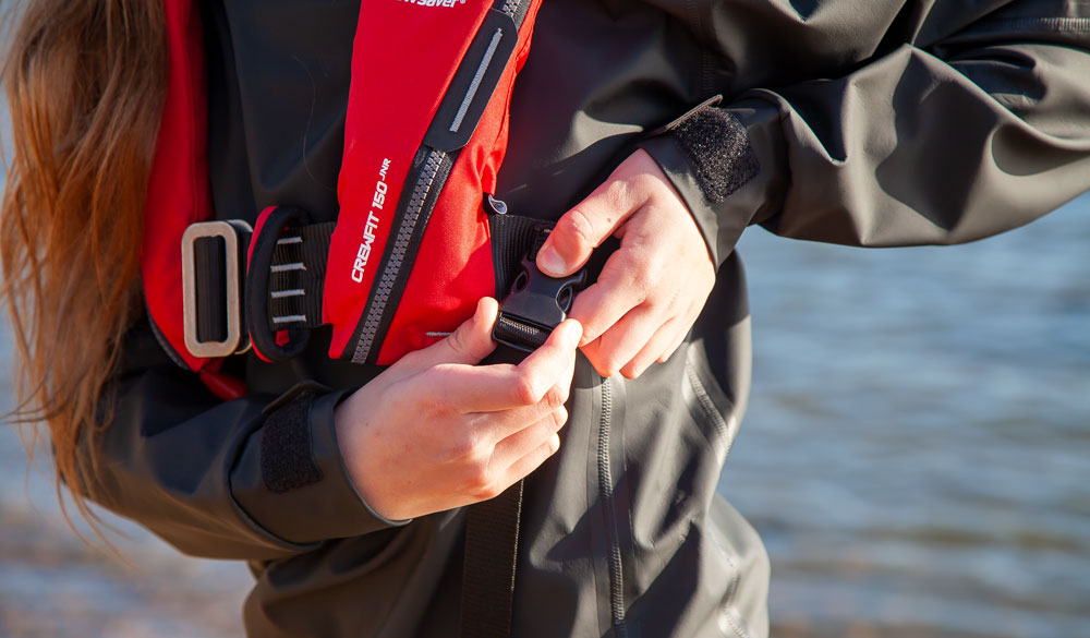 Girl securing leg strap on lifejacket