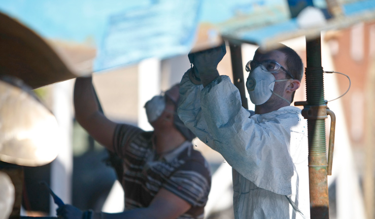 Wide shot of two men using antifoul paint