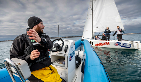 Man coaching 4 sailing racers 