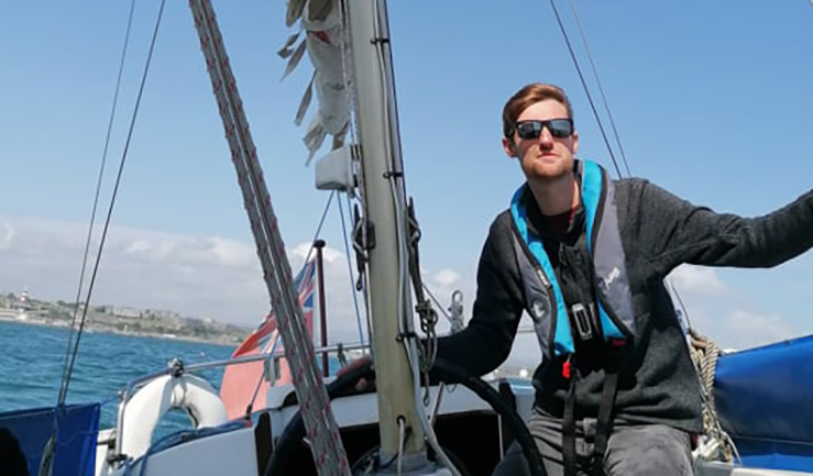 Trinity House RYA Yachtmaster Scholarship recipient Toby Bevington at the helm of a sailing yacht