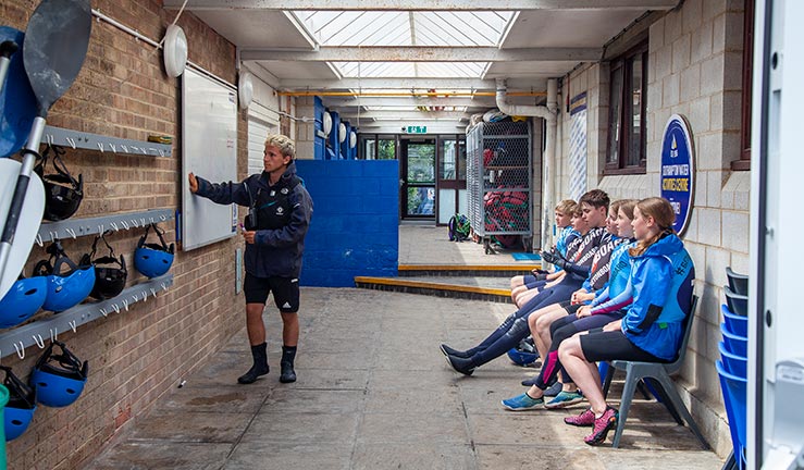 wide shot of an instructor in front of a white board explaining something to a group of children