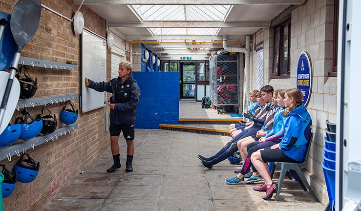 wide shot of an instructor in front of a white board explaining something to a group of children