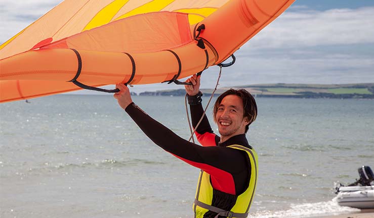 Man learning to use a wing on the beach during an RYA Learn to Wingsurf course