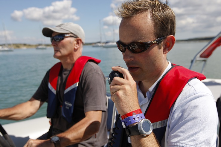 Two men on a boat use a radio