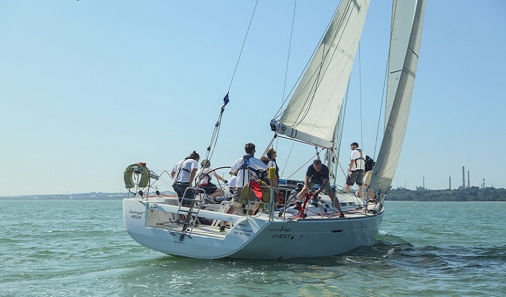 A group of men are sailing on a yacht on the Solent.