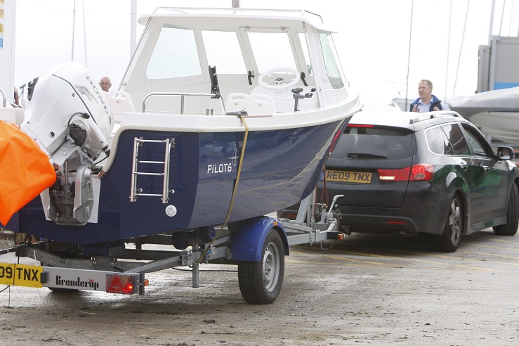 A boat is being towed by a car