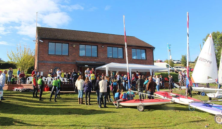 Wide shot of a sailing club with a large group of people outside