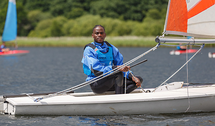 Mid shot of sailor sailing a dinghy 