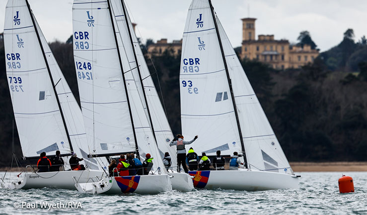 British Keelboat Academy sailing upwind in J70s on the Solent with Osborne House on shore.