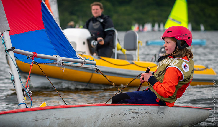 OnBoard junior sailor in a Topper dinghy with a coach boat at the BYS North Junior Champs at Ullswater, 2022