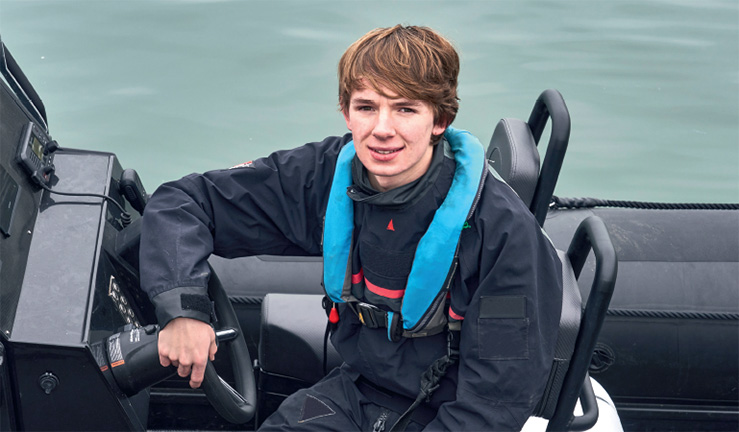 posed shot of young man sitting at steering wheel of a motor boat