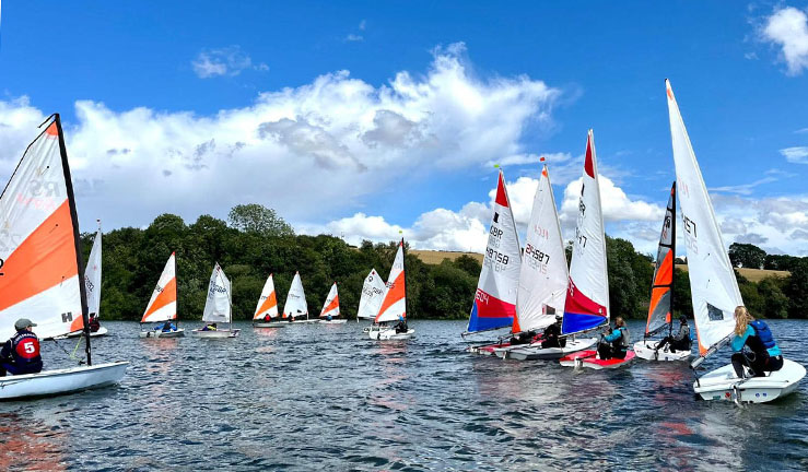 A dozen junior dinghies including Toppers and RS Teras on the water at Ulley SC on a sunny day for the North East & Yorkshire Youth Sailing traveller series. 