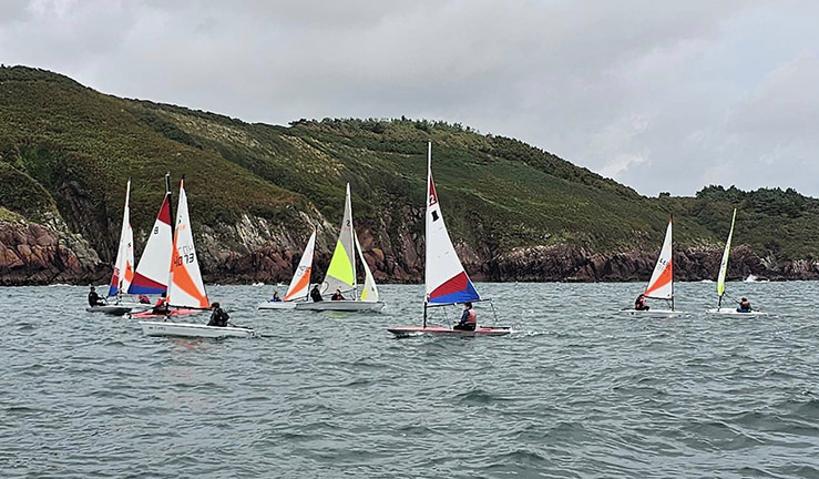 Eight colourful junior dinghies out sailing at a Dragon Series event at Dale SC