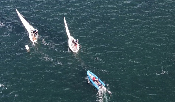 Drone picture of two boats match racing and RIB at the RYA Winter Women's Match Racing at WPNSA 2023