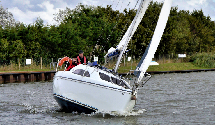 John Redding sails towards camera in sailing cruiser 
