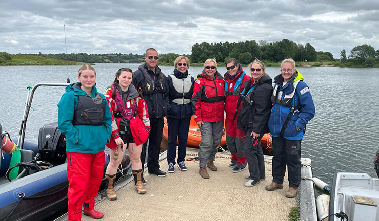 Half a dozen Aspiring Female Powerboat Instructors standing on a pontoon at Carsington during a weekend course to gain their qualification.