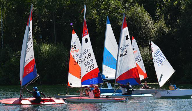 Half a dozen different junior dinghies with colourful sails on a sunny day competing on the lake at Ripon SC with the NE & Yorkshire Youth Traveller Series.