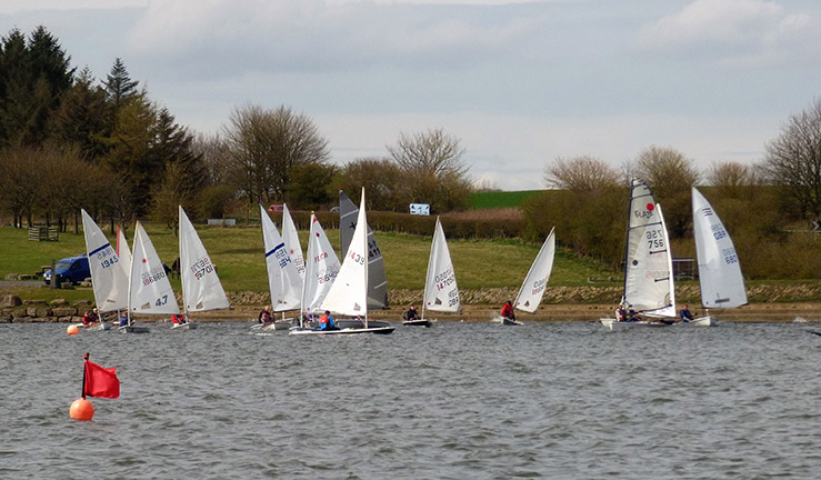 Fleet of singlehanded boats racing towards a mark at Scaling Dam SC.