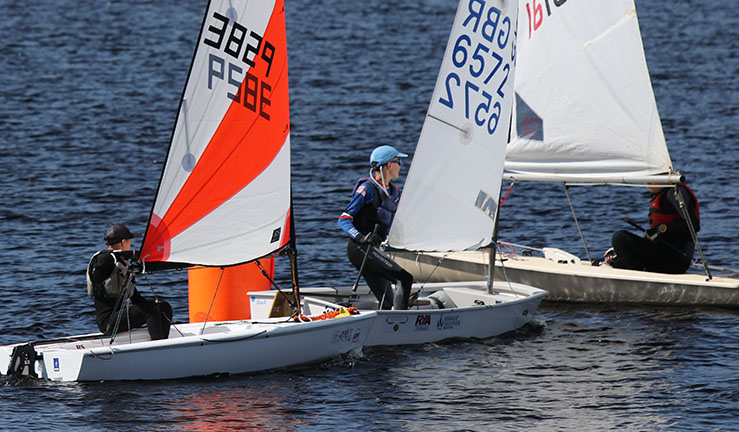 Close racing between an RS Tera, Optimist and ILCA at a NE & Yorkshire Youth Traveller Series open meeting at Teesdale SWC, 2022.