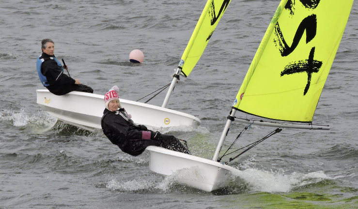 Two dinghies sail towards the camera with yellow sails - it is quite breezy 