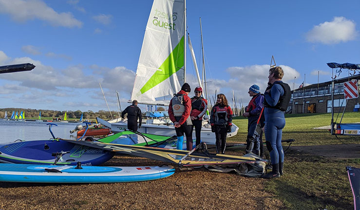 Instructors on shore with boards and boats.