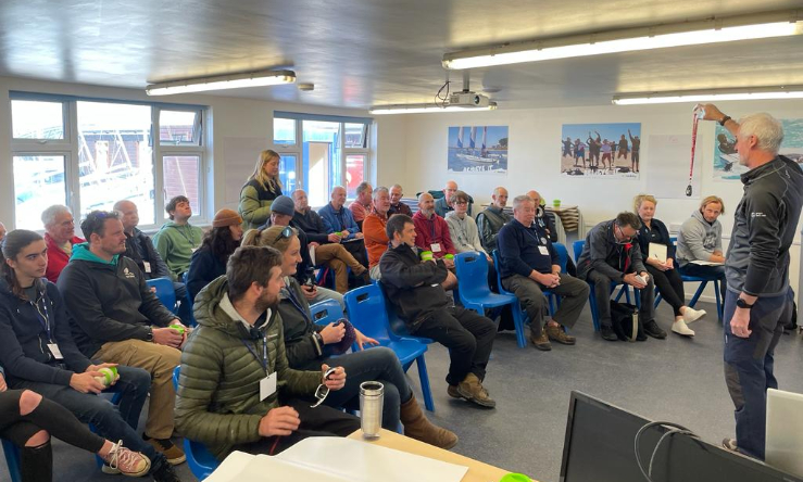 Lots of people sitting in a classroom with a presenter in front of them