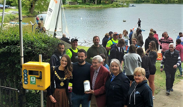 Group of people outside Cransley Sailing Club with new defibrillator including Richard Allen, Chairman of charity RALPHH, Mayor of Kettering, Cllr Emily Fedorowycz and Commodore Sue Bull. 