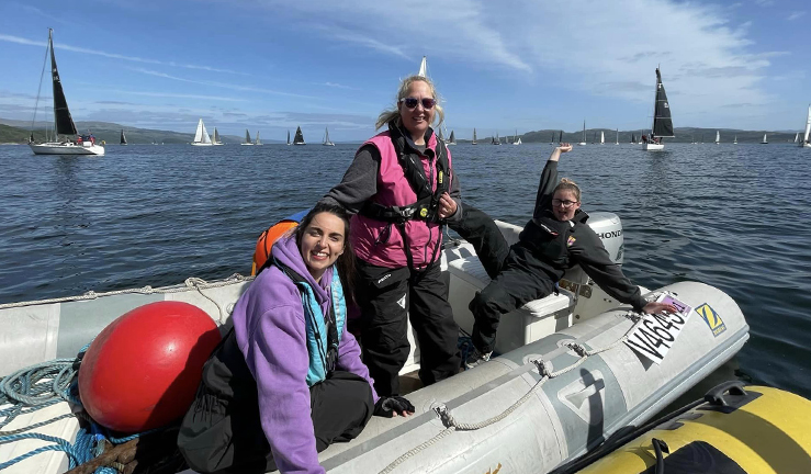 Women helping lay race buoys onboard inflatable power boats on a Scottish Loch in the sunshine. 