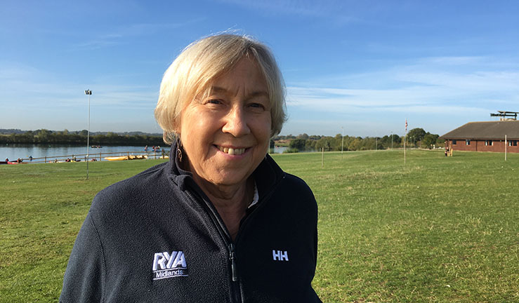 Headshot picture of new RYA Midlands chair Judy Lambourne taken at Whitemoor Lakes Activity Centre, with playing field and lake in the background.