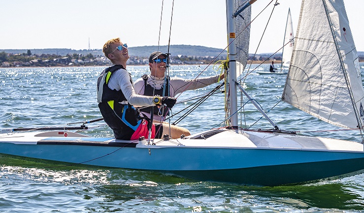 Two men are racing a small boat at Whitstable Sailing Club