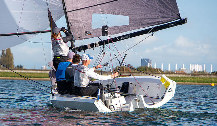 Ted Blowers and Team Absolute concentrating downwind with the kite up racing an RS21 at the RYA National Match Racing Grand Finals 2023.