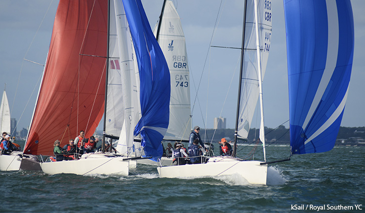 Four J70s racing downwind in sunshine with blue and red kites flying at the British Keelboat League final 2023.