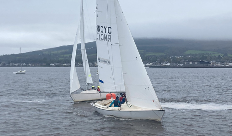 Two keelboats match racing upwind at Royal Northern & Clyde YC on a grey day with mountains in background, at the Ceilidh Cup 2023.