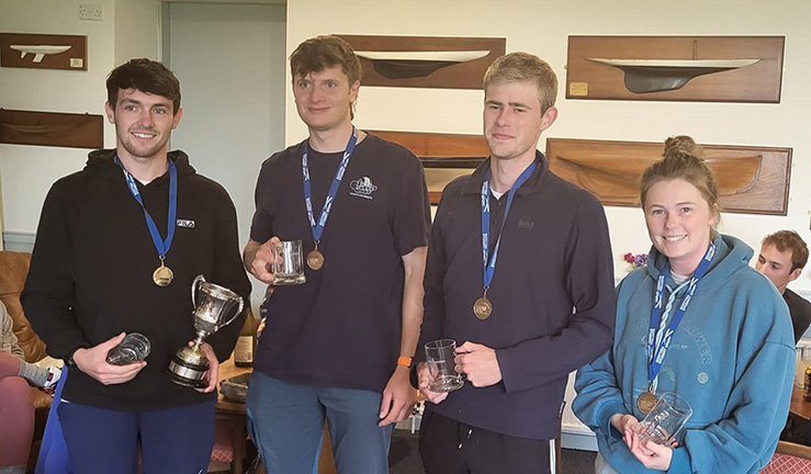 Four sailors from Strathclyde University - three boys and a girl - in the clubhouse at Royal Northern & Clyde YC with medals and trophies after winning the 2023 Ceilidh Cup match racing event.