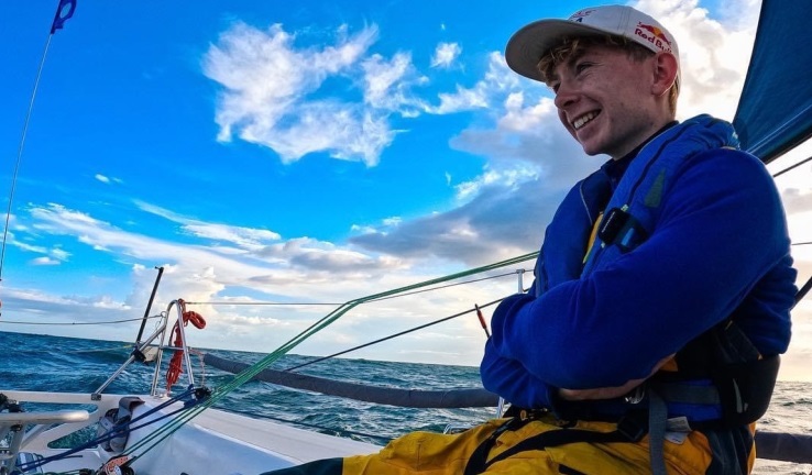 Dan Corbett relaxing aboard a race yacht with blue skies and calm sea.
