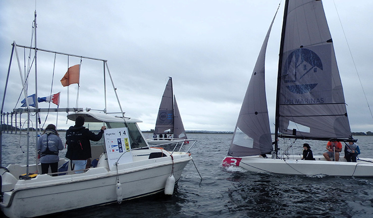 Two RS21 keelboats and a committee boat with flags up on a grey day at the RYA Summer Match Racing Q2 event at Queen Mary SC, 2023.